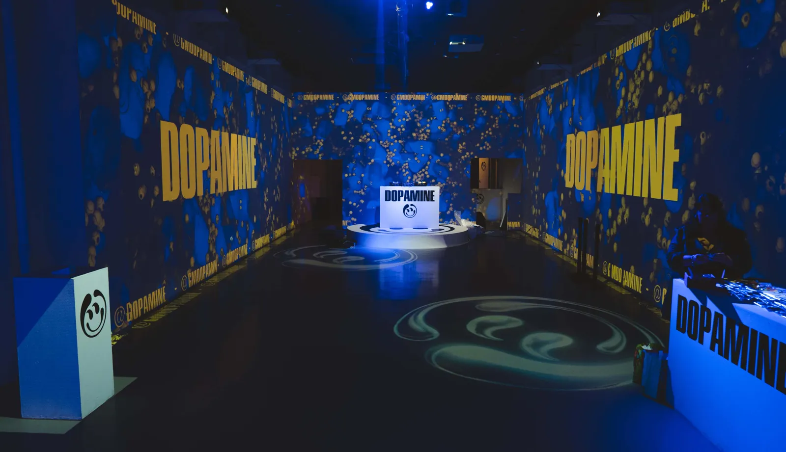 Dopamine 3D visuals projected across every wall of a long hall