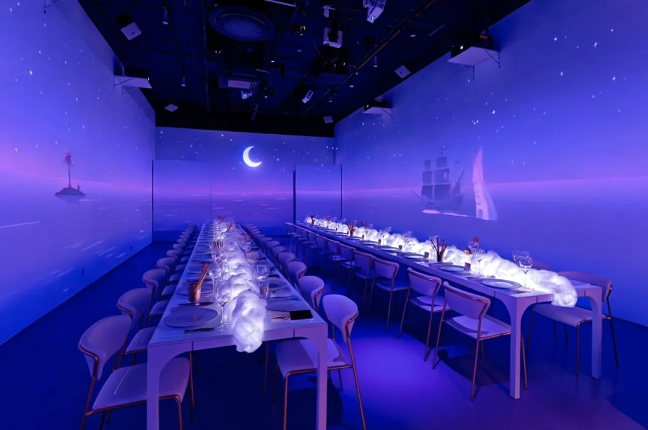 Long dinner table inside a projected night sky